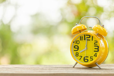 Close-up of yellow clock on table