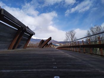 Surface level of footbridge against sky