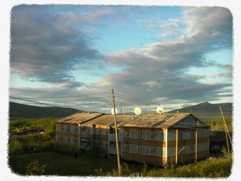 Houses against cloudy sky