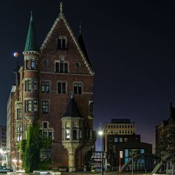 Low angle view of building at speicherstadt against sky during lunar eclipse