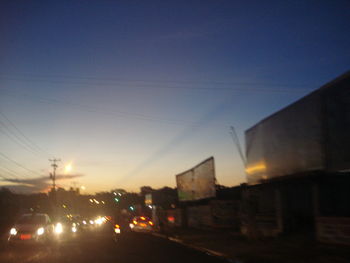 Illuminated road against sky at night