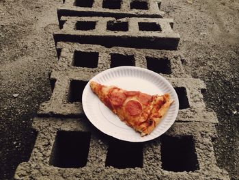 High angle view of pizza slice in plate on street