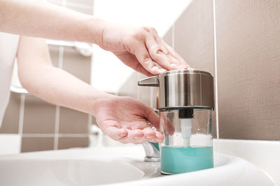 Midsection of woman pouring drink in glass