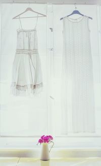 Low angle view of white dresses hanging from coathangers