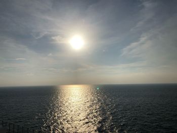 Scenic view of sea against bright sun