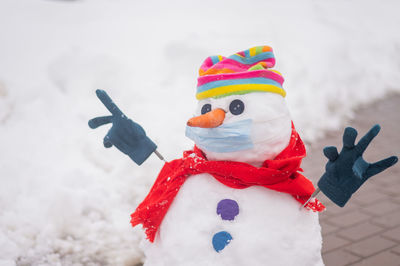 Close-up of snowman on footpath