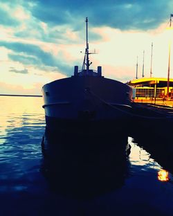 Boats in sea at sunset