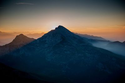 Scenic view of snowcapped mountains against sky during sunset