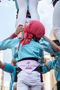 Rear view of women standing on umbrella