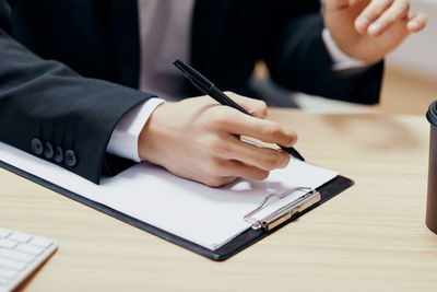 Midsection of businessman working on table