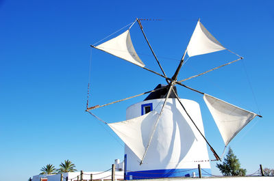 Low angle view of traditional windmill against clear blue sky