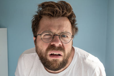 Close-up portrait of young man against wall