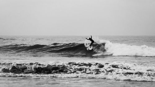 Man surfing in sea against clear sky