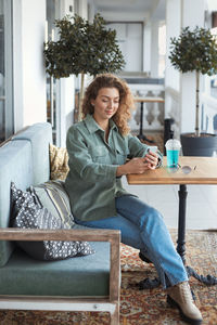 Full length of woman sitting at cafe