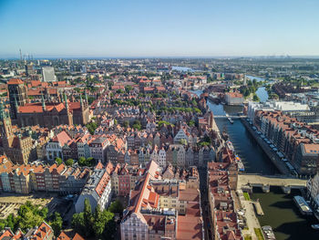 High angle view of illuminated city by river against sky