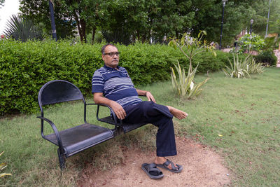 Isolated man enjoying at outdoor park chair at evening from flat angle