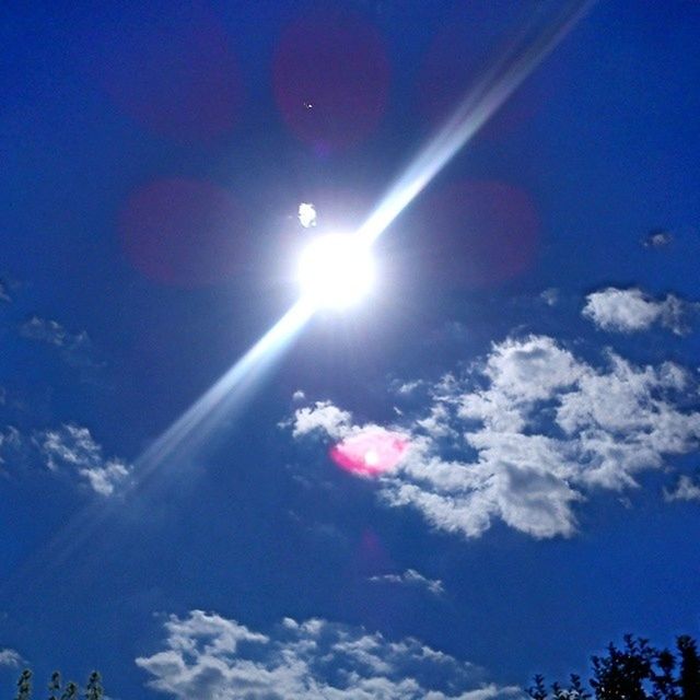 low angle view, sun, blue, sunbeam, sky, lens flare, sunlight, cloud - sky, beauty in nature, bright, nature, sunny, day, tranquility, cloud, no people, outdoors, scenics, vapor trail, sky only