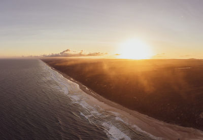 Aerial of sea against sky during sunset