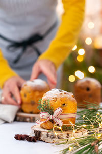 Traditional italian christmas cake panettone on a rustic table. female hands are holding cake