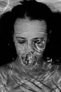 Close-up portrait of woman underwater, symbolism 