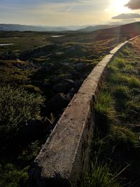 Scenic view of land against sky during sunset