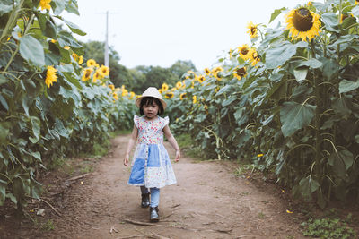 Full length portrait of girl standing on field