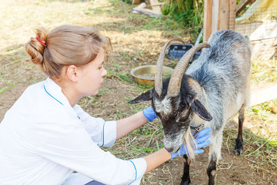 Side view of woman with goat