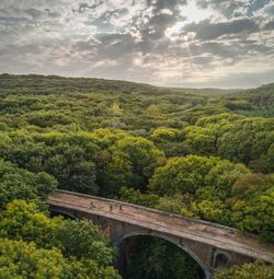 Arch bridge over landscape against sky