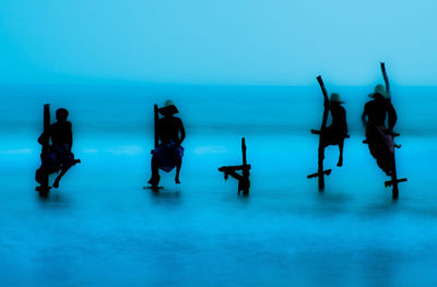 People at beach against blue sky