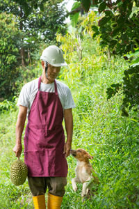 Man with dog standing by plants
