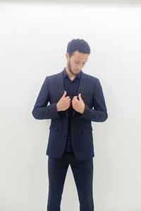 Young man standing against white background