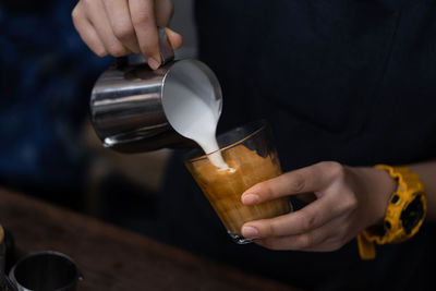 Midsection of person preparing coffee