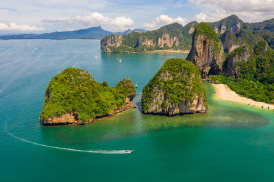 Aerial view seascape phra nang cave beach with traditional long tail boat sailing on the sea 