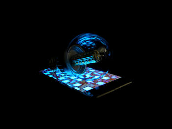 Close-up of illuminated lighting equipment against black background