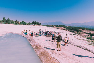 People at beach against sky