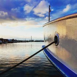 Boat moored on sea against sky during sunset