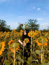 View of flowering plants on field against sky