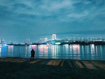 View of bridge over calm sea against cloudy sky