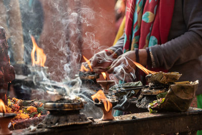 Devout hands of pilgrims light oil candles on the altar where the vishnu lingam is located 