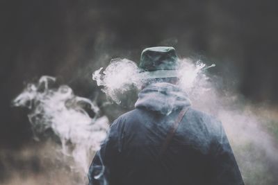 Rear view of man smoking outdoors