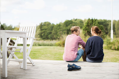 Rear view of happy mature couple communicating on porch