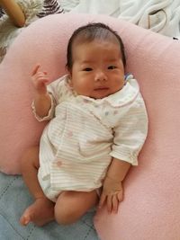 Portrait of cute baby lying on bed