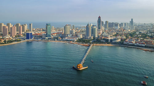 High angle view of city by sea against sky