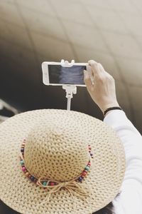 High angle view of person wearing hat while taking selfie with mobile phone