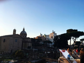 Buildings in city against clear blue sky