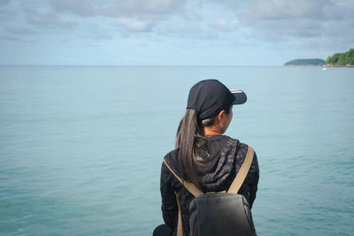 Rear view of woman looking at sea against sky