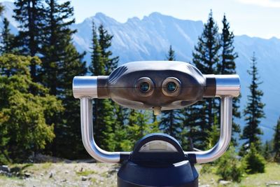 Close-up of coin-operated binoculars against mountain
