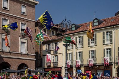 Group of people outside buildings against sky