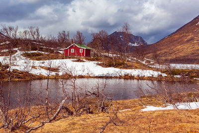 Scenic view of lake by snowcapped mountain against sky