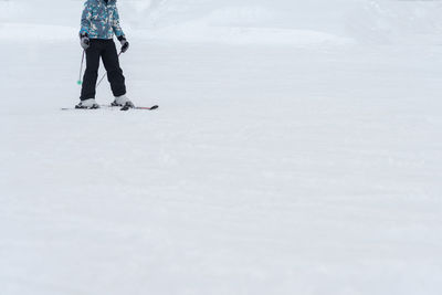 Low section of person snowboarding during winter